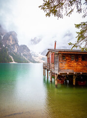 Fototapeta premium Sonnenaufgang am Pragser Wildsee See in Italien Dolomiten Steg mit Booten Berg Alpen Tirol Südtirol Landschaft / Lago di Braies lake in Italy Dolomites Jetty with boats Mountains Alps tyrol Landscape