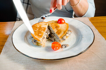 woman eating potato pancakes with sauce
