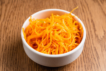 carrot salad with garlic on wooden background