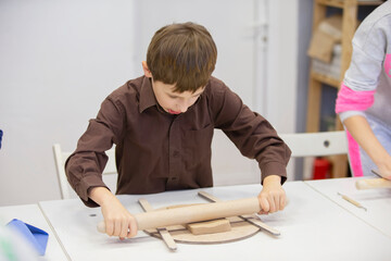 A little boy learns to sculpt from clay.