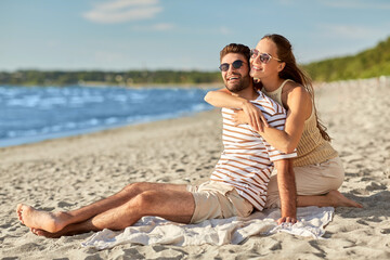 leisure, relationships and people concept - happy couple in sunglasses hugging on summer beach