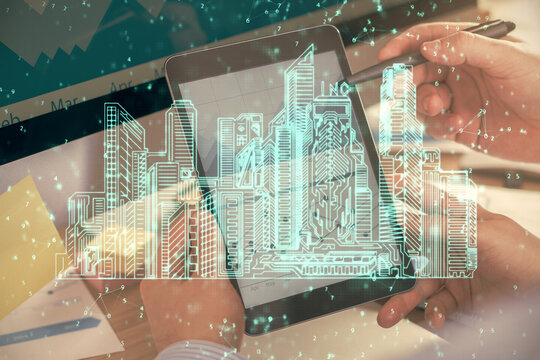 Double exposure of man's hands holding and using a digital device and city drawing.