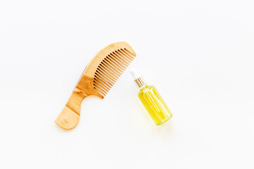 Essential oil for hair care with wooden hair comb