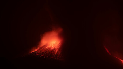 Eruzione vulcano Etna in Sicilia con esplosioni di lava incandescente e fumo di notte