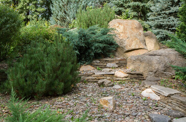 A plot of a natural park with stones and plant bushes.