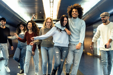 Happy young friends hanging out in subway underground metropolitan