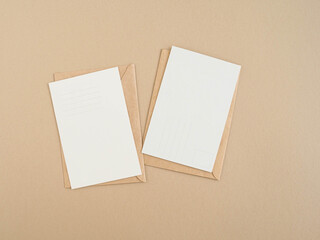 Two blank postcards and envelopes on beige background