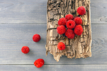 Rubus illecebrosus, Japanese raspberry on a wooden board - obrazy, fototapety, plakaty