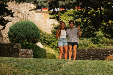Beautiful couple enjoying the sunset on a swing hanging from a tree