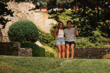 Beautiful couple enjoying the sunset on a swing hanging from a tree