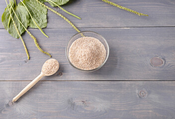 Fototapeta na wymiar psyllium is the husk of plantain seeds in a glass cup on a wooden background.a useful prebiotic