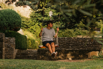 Young boy enjoying on the swing during golden hour