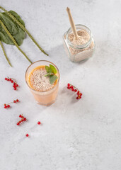 a smoothie made from red currant berries and coconut milk with the husk of plantain seeds. the concept of healthy food