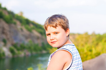 A child sits on the top of a beautiful canyon and looks at the water in it. The bank of the canyon.