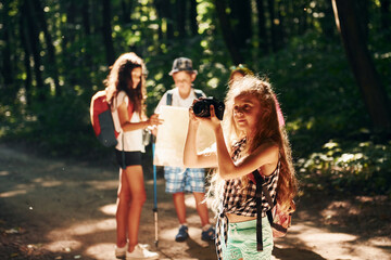 With touristic equipment. Kids strolling in the forest