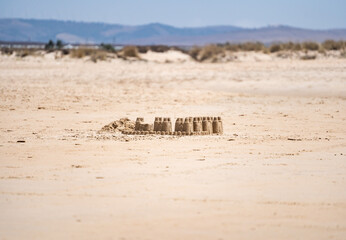 Small sand castles on the sandy beach on the coast