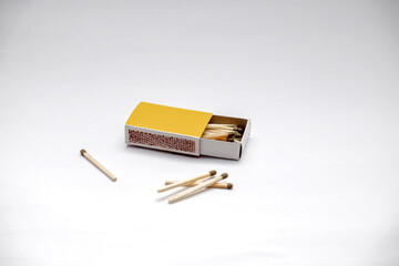 Several matches inside and outside the matchbox stand on a white background. Selective focus. Space for text.