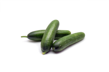 Three green cucumbers stand on a white background. Selective focus. Space for text.