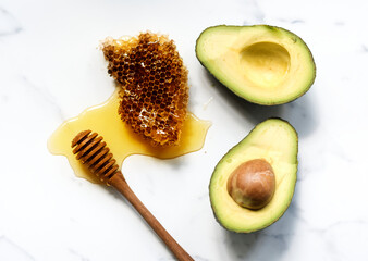 Aerial view of fresh avocado and honey on white marble background