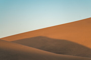 Fototapeta na wymiar The sunset view of the dunes in deserts in Dunhuang, China.