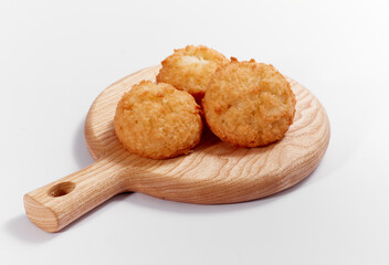 Toasted coconut cake in cuttung board, on white background. Nobody. Soft lighting
