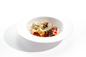 Cannelloni pasta with seafood and Parmesan cheese. Lasagna cannelloni pasta stuffed with tomato sauce and fried octopus. Italian pasta in white plate isolated on white background .