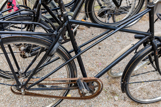Hoge Hexel, The Netherlands - August 20, 2021: Closeup of vintage design black bike stationed in park with rusted bicycle chain.