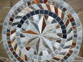 geometric abstraction with chaos of elements forming a dynamic pattern, abstract texture of stone or ceramic tiles in gray-beige tones, fragment of exterior design with figured mosaic