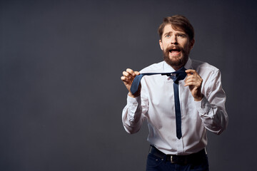 bearded man in a white shirt pulls the tie isolated background