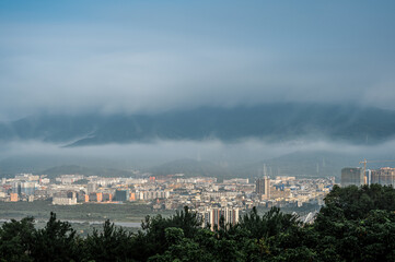 In the morning, the sun shines on the town under the advection fog