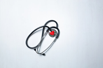 flat lay red heart white stethoscope on white Doctor's table. health concept. Copy space