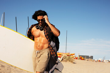 Handsome man with surfboard. Young handsome man preparing for the surf.