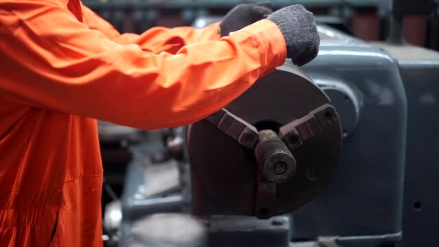 Professional Asian man Industry worker in safety ear muff working in machinery factory. Male labor foreman technician working with metal machine. Manufacturing factory and build construction concept