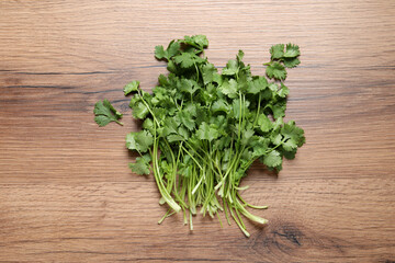 Bunch of fresh aromatic cilantro on wooden table, top view