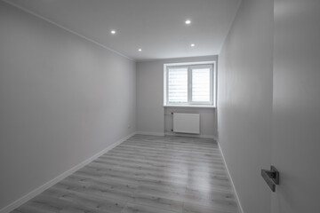Modern interior of empty room. Apartment after renovation. White walls. Light parquet floor. Black and white.