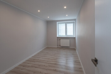 Contemporary apartment. Light interior of renovated room. Parquet floor. Window on wall. Nobody.