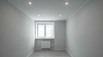 Apartment after renovation. Modern light interior of room without furniture. Heating battery under window.