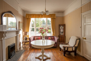 Vintage British living room with wooden floors and lilies on the table