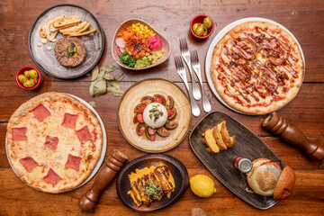Top view image of pizzas and Mediterranean food dishes. Beef burger, burrata salad, guanciale,...