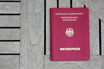 Top view of the red German passport on the wooden surface