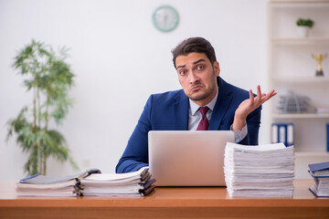 Young businessman and too much work in the office