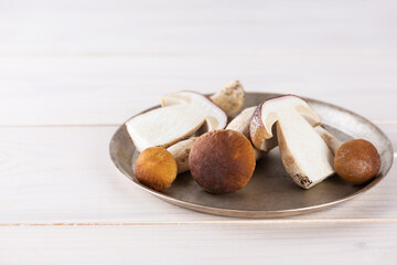 Porcini mushrooms in a plate on a wooden table. Horizontal orientation, copy space.