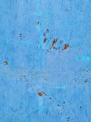 texture of old painted rusty blue wall or garage door with peeling and cracked paint and corrosion