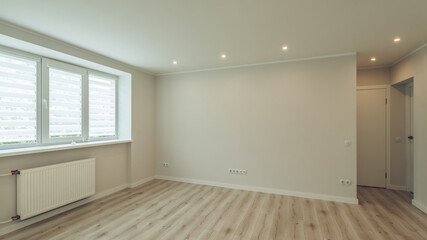 Contemporary bright interior of empty room. Apartment after renovation. Beige parquet floor. White walls.