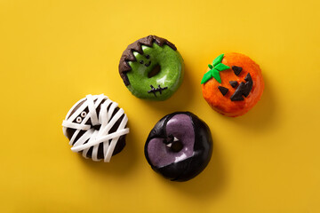 Assortment of Halloween donuts on yellow background