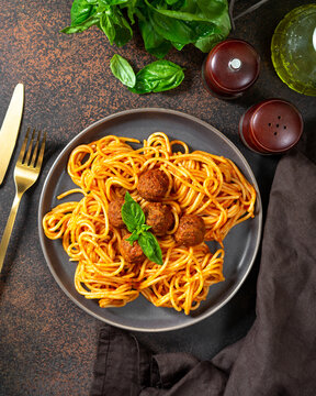 Spaghetti with meatballs in tomato sauce in a ceramic plate top view. Traditional Italian pasta