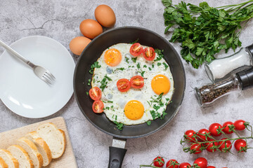 Fried eggs in a frying pan. On a concrete gray background. On the plate