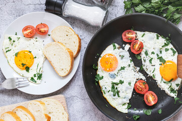 Fried eggs in a frying pan. On a concrete gray background. On the plate