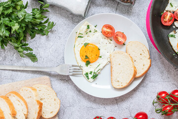 Fried eggs in a frying pan. On a concrete gray background. On the plate