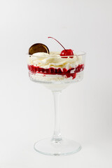 Traditional Italian dessert - Tiramisu dessert with cherry. Served in a tall glass over white background.